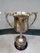 A silver plated twin handled trophy on wooden stand, height 34.