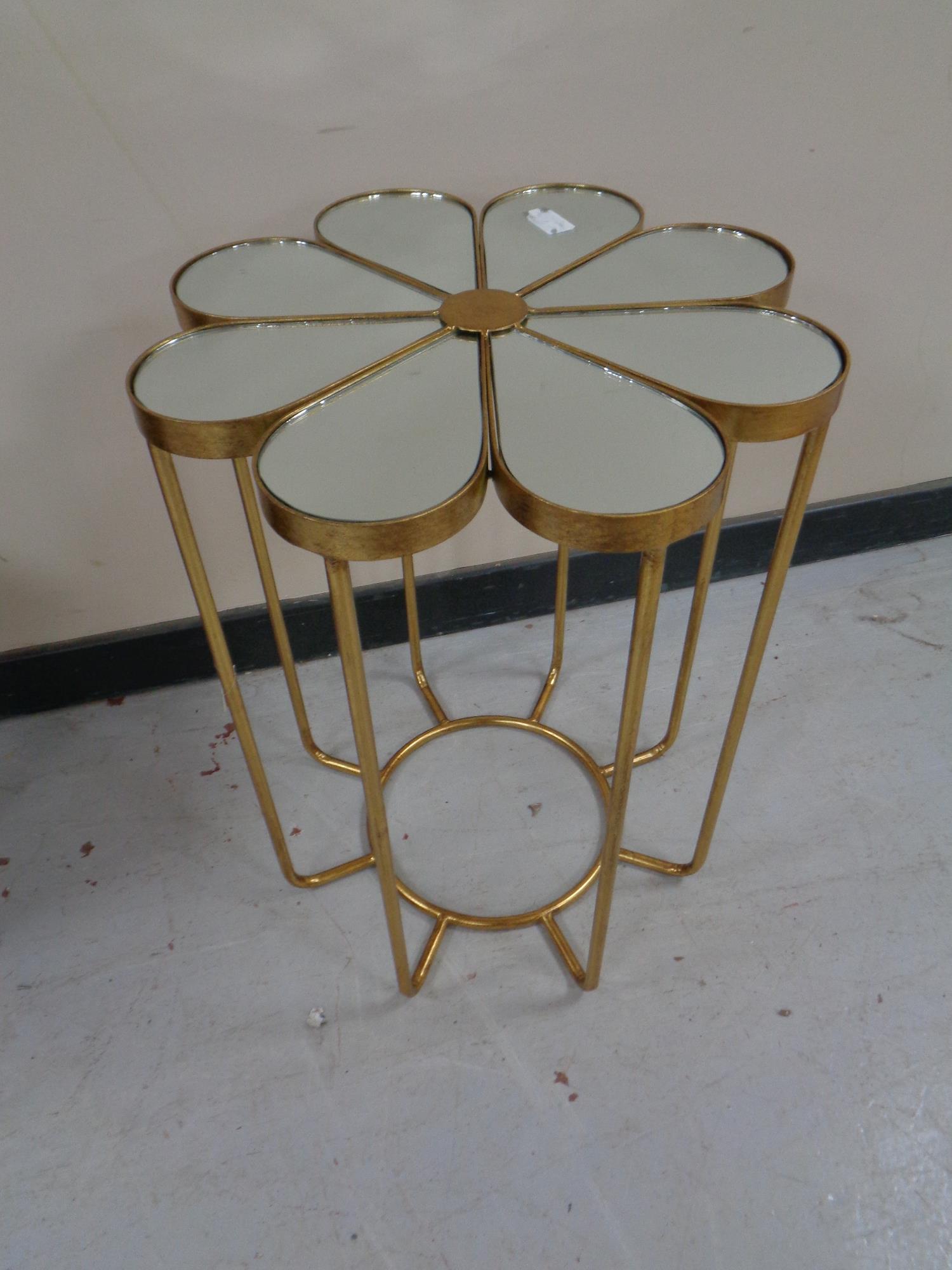 A contemporary metal mirrored topped occasional table in the form of a flower