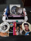 A box of Elvis Presley memorabilia to include records, books, framed pictures, collector's plates,