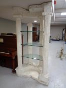 A Grecian style demi lune display stand with column supports