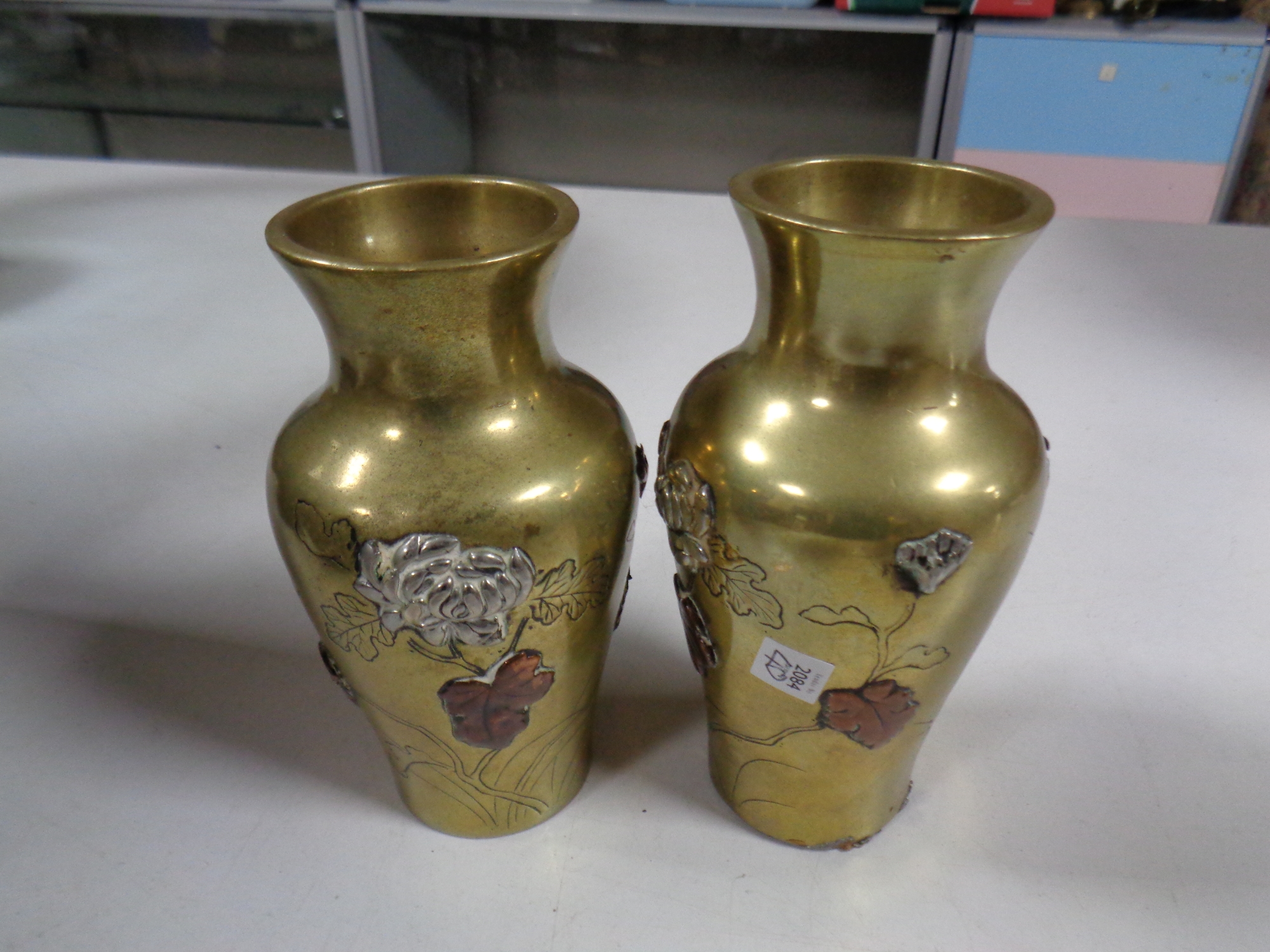 A pair of oriental style brass embossed vases, height 12.