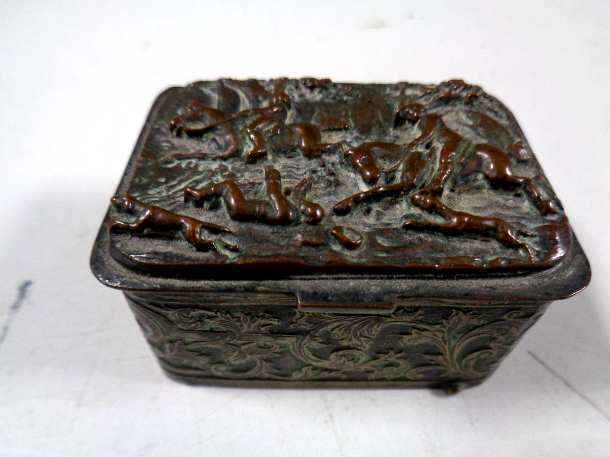 An antique plated embossed snuff box depicting a hunting scene (as found)