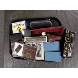 A tray containing miscellaneous to include pens, vintage money boxes in the form of books,