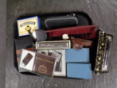 A tray containing miscellaneous to include pens, vintage money boxes in the form of books,