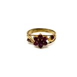 A ruby cluster ring on yellow metal shank,