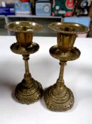 A pair of eastern brass candlesticks,