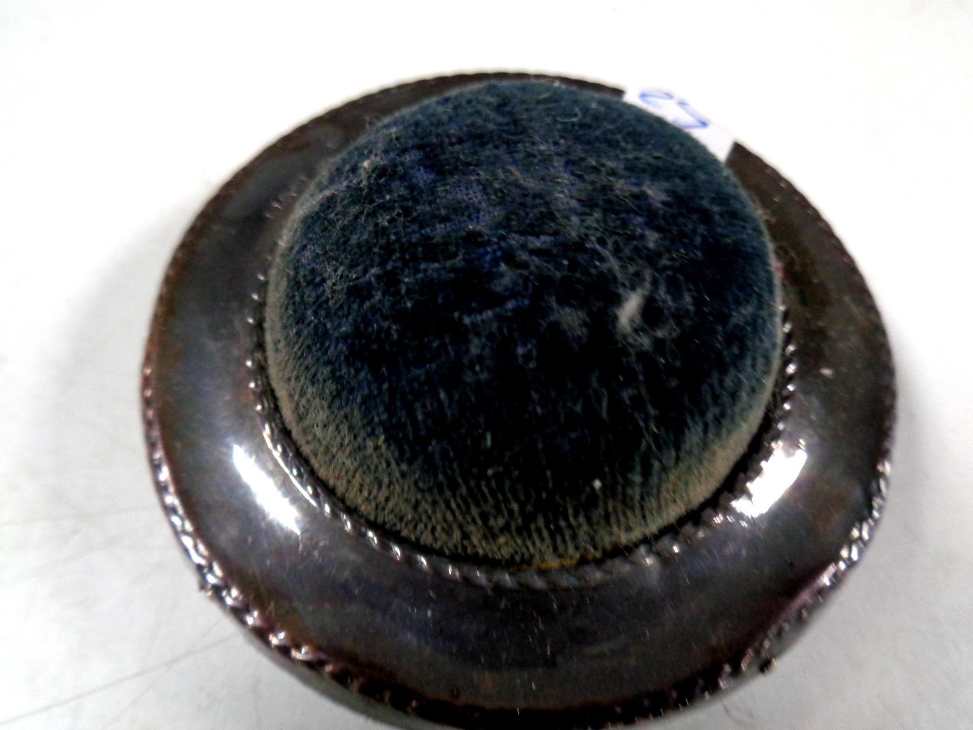 A circular silver pin cushion