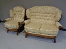 An Ercol two piece wingback cottage suite comprising of two seater settee and armchair