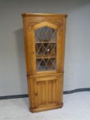 A carved oak leaded glass door corner cabinet,