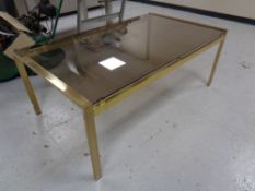 A late 20th century brass coffee table with smoked glass top