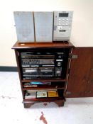 A Sanio hifi in cabinet together with assorted LPs and cassettes,