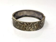 An antique white metal hinged bangle, likely silver though unmarked.