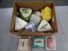 A box containing antique and later ceramic cheese and butter dishes