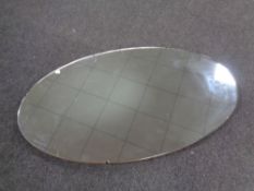 A large oval frameless mirror