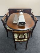 An inlaid mahogany Regency style sideboard on raised legs together with a twin pedestal dining