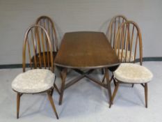 An Ercol solid elm and beech circular drop leaf table together with a set of four high back chairs