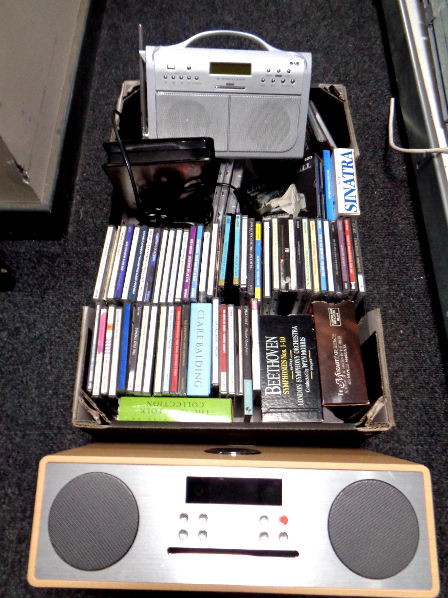 A box containing assorted CDs together with a Magorita CD player and a silver crest DAB radio