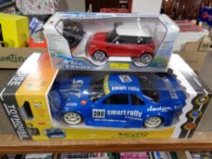 A remote controlled Smart Rally 1/10 vehicle together with a further remote controlled mini