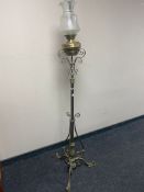 An ornate brass oil standard lamp with etched frosted glass shade and brass reservoir