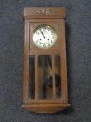 An Edwardian oak cased eight day wall clock with silvered dial
