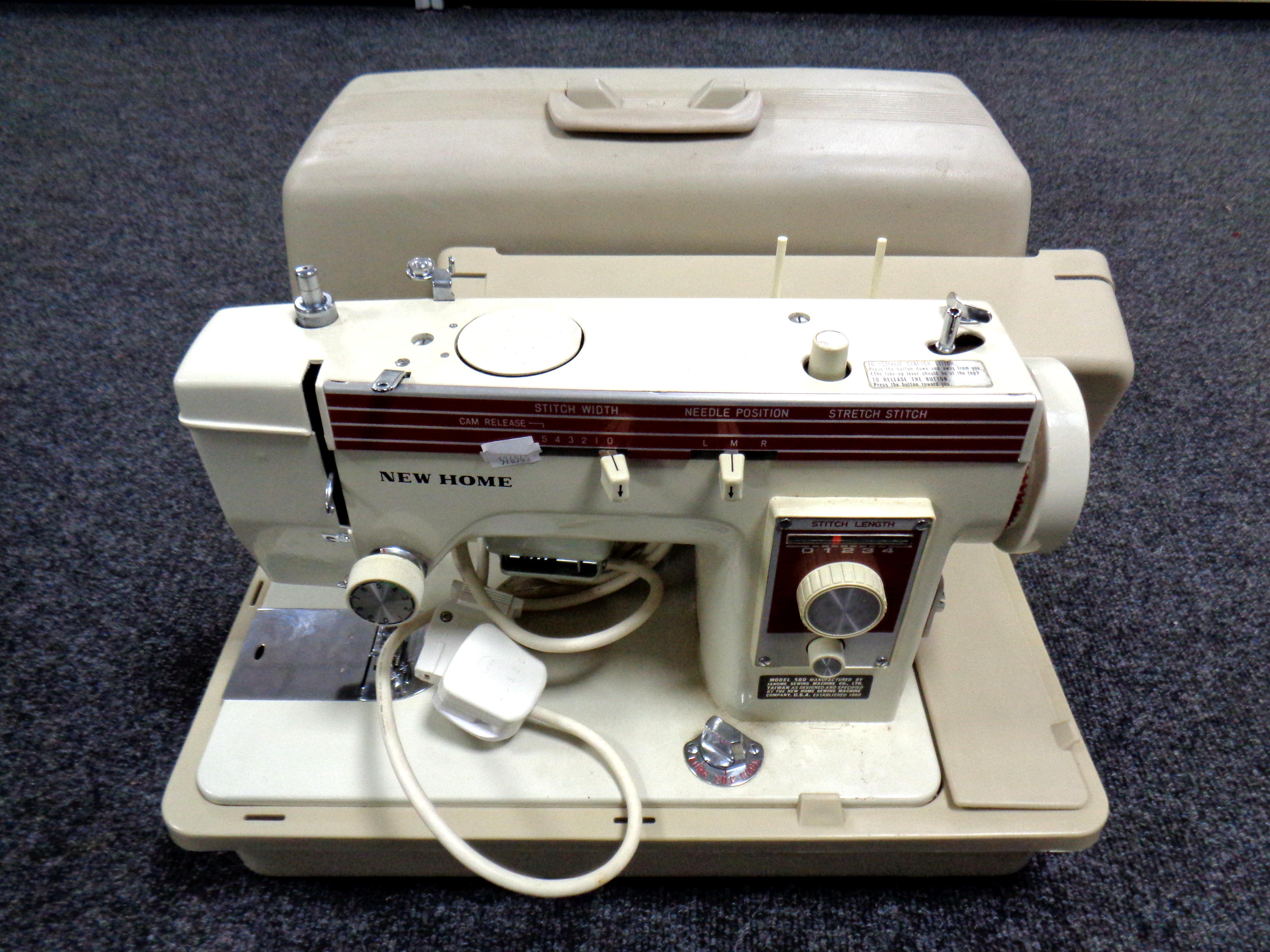 A cased New Home electric sewing machine