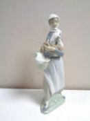 A Lladro figure of a lady carrying a hen