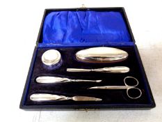 A cased six piece manicure set with silver lids and handles