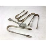 Five pairs of Georgian/William IV sugar tongs and a spoon,