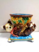 A Minton majolica jardiniere in the form of a cat playing with a wicker basket on cushion,
