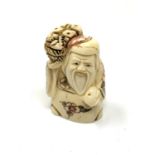 A carved hardwood Chinese netsuke - Village elder with bread basket