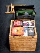 A wicker hamper containing assorted books together with a box containing artist's easel,