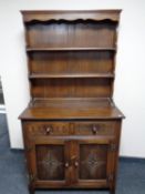 A carved oak dresser fitted two drawers and cupboards beneath