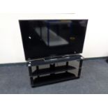 A Toshiba 49'' LCD TV with remote on black glass stand