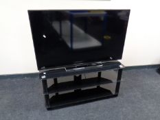 A Toshiba 49'' LCD TV with remote on black glass stand