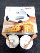 A boxed Ideline sandwich toaster together with two Wilkin and Sons cheese bakers with knife