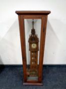 A fretwork wooden model of Big Ben with clock movement in a pitch pine and glass display case,