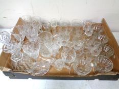 A box containing a large quantity of assorted drinking glasses together with a decanter with