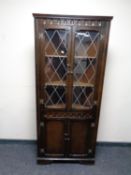 A leaded glass oak corner cabinet