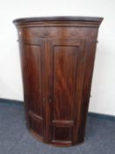 A George III inlaid mahogany bow front corner cabinet