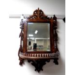 A Victorian fretwork framed mirror with demi lune shelf