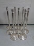 Eight metal bollards with canvas dividers bearing advertising