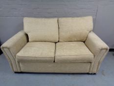 A Marks & Spencer settee upholstered in a beige fabric