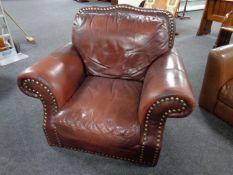 A burgundy studded leather armchair
