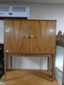 A walnut effect two door cabinet with mirrored back