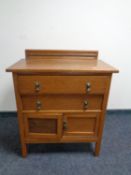 An Edwardian oak two drawer chest fitted cupboard beneath