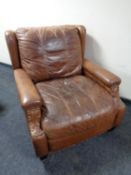 A brown studded leather armchair