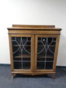 An early 20th century oak bookcase with leaded glass doors
