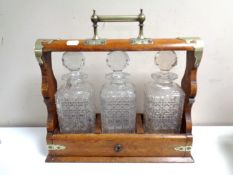 An Edwardian oak and silver plate mounted three bottle Tantalus,