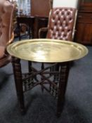 An eastern circular brass topped occasional table