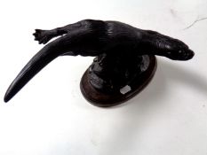 A resin figure of an otter on a wooden plinth by Tom Mackie